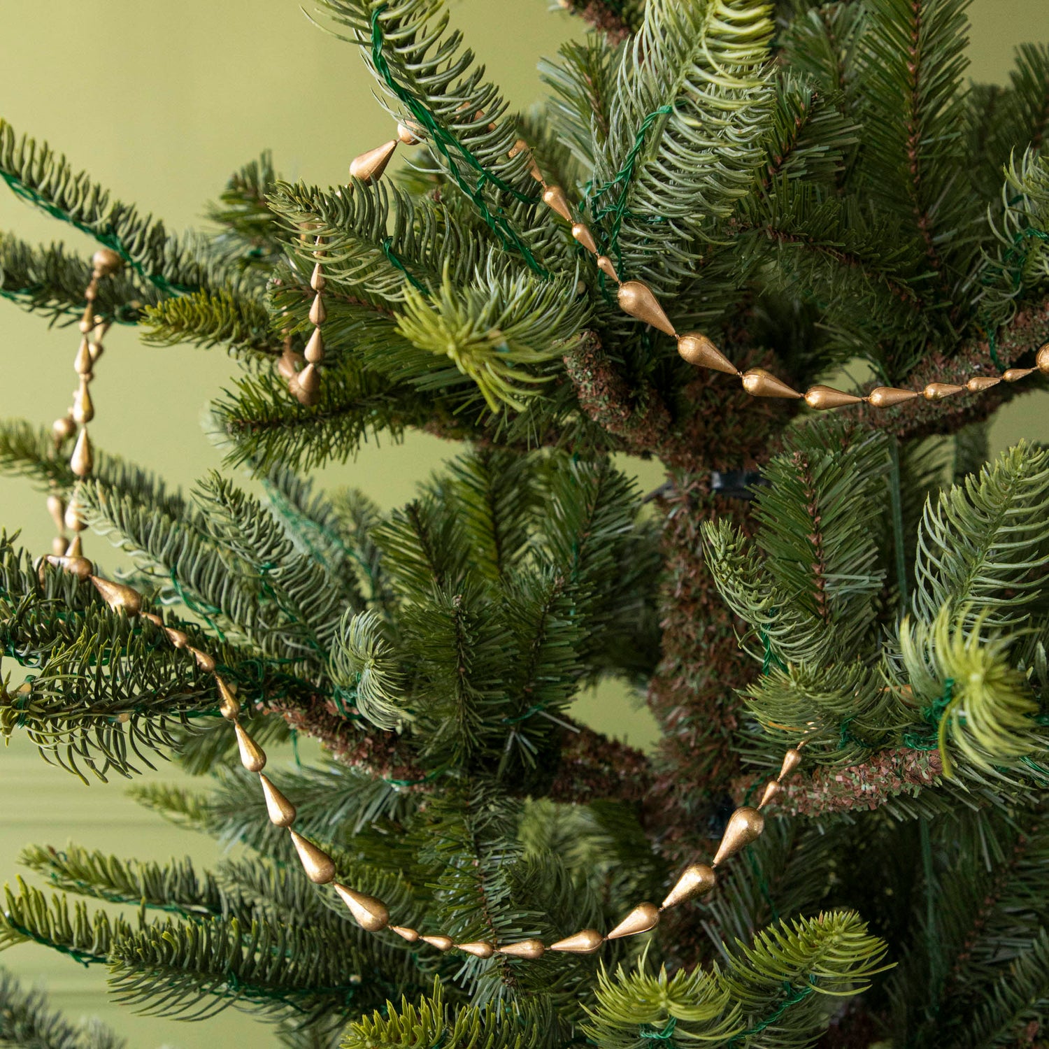 drop gold garland hanging in a tree