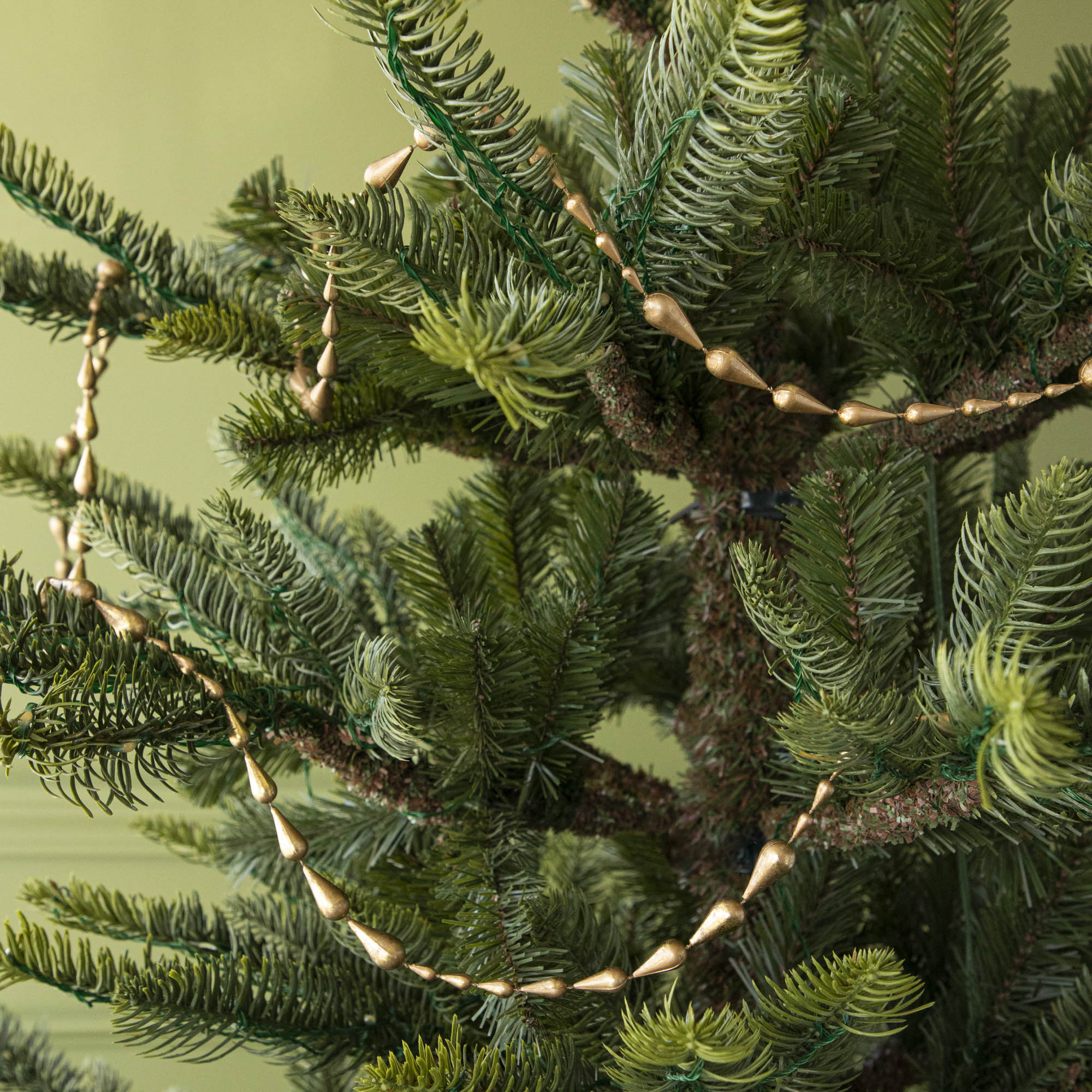 Gold Drop Garland draped on a tree.