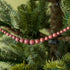 red sparkly ball garland hanging in a tree