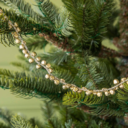 Festive bell garland draped on a tree.