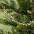 Festive bell garland draped on a tree.