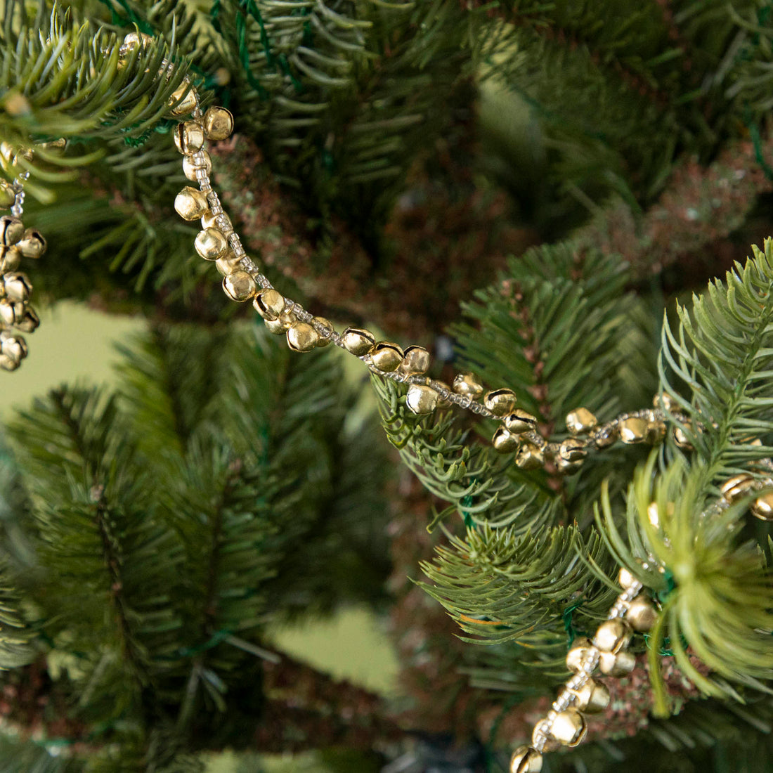 bell garland hanging in a tree