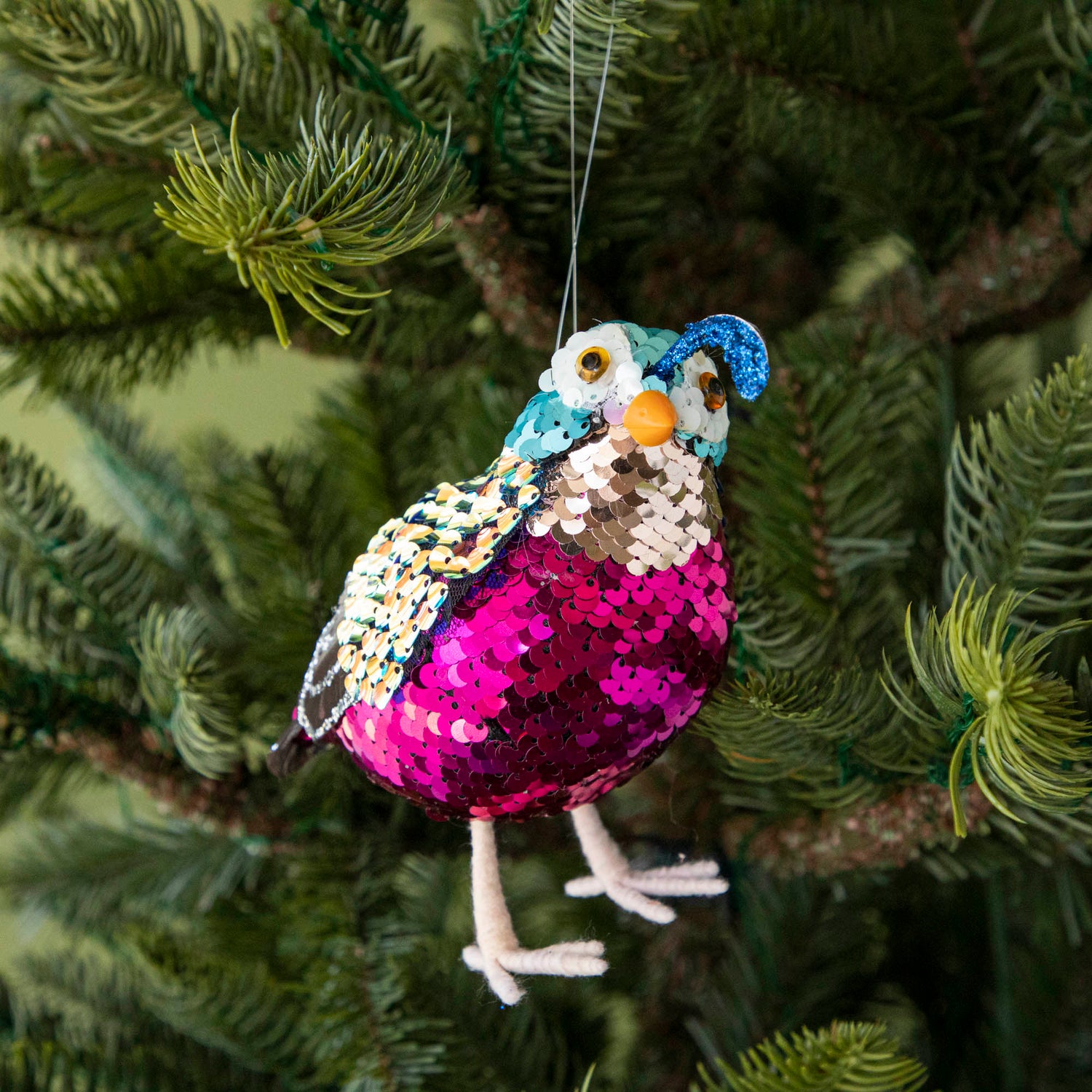 sequin quail hanging in a tree