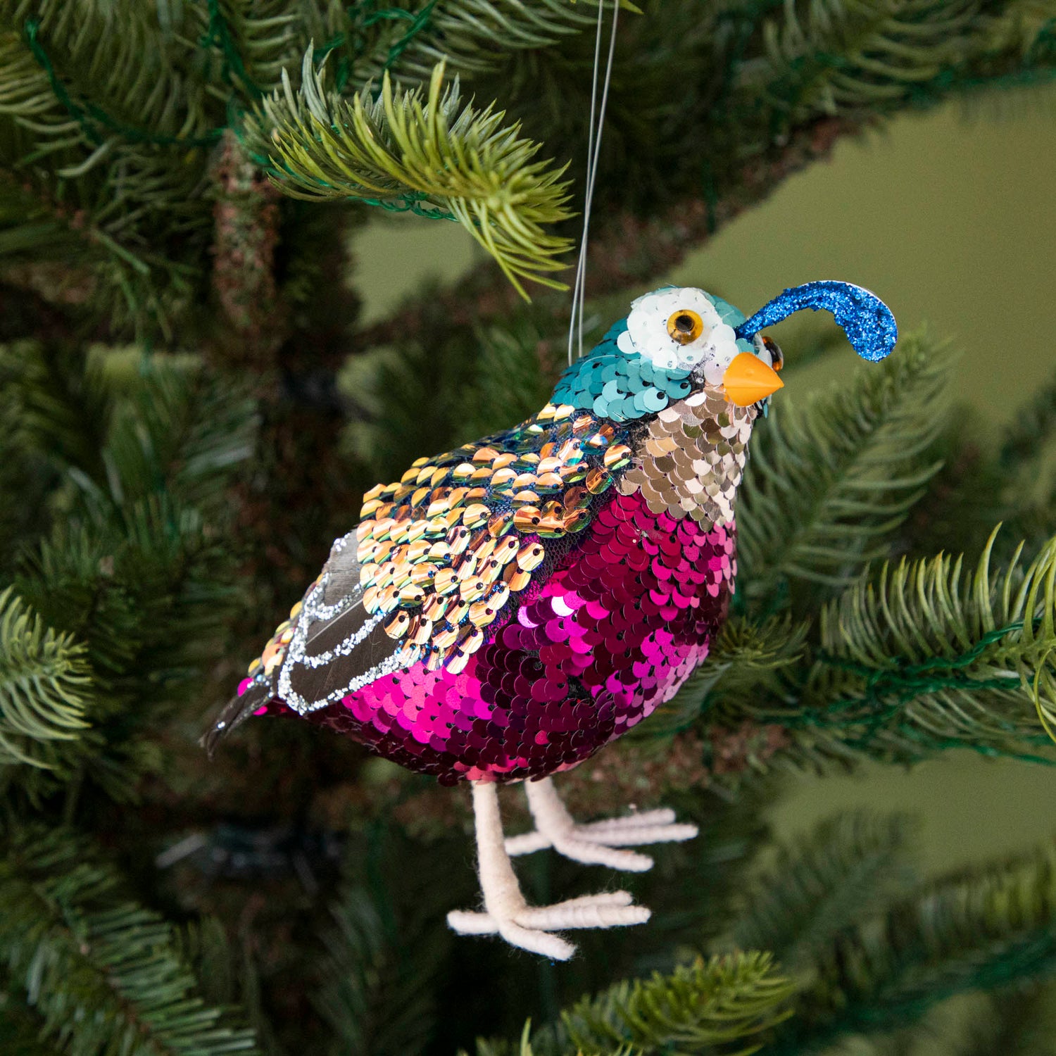 Sequin quail hanging in a tree