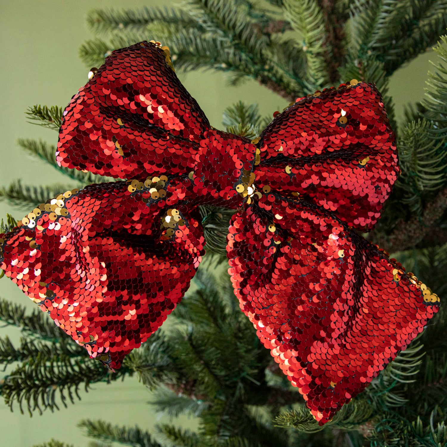 close up of red sequin bow in tree