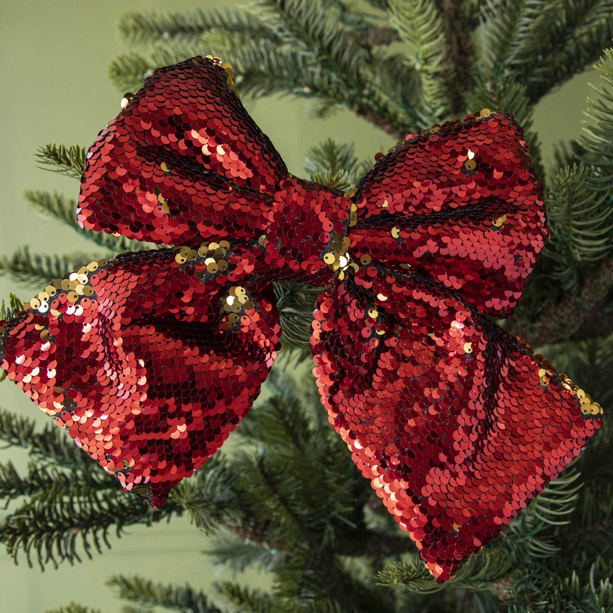 close up of red sequin bow in tree