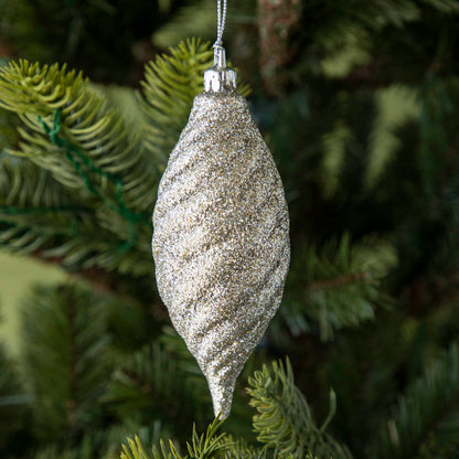 Drop shape silver glitter ornament hanging on a tree.