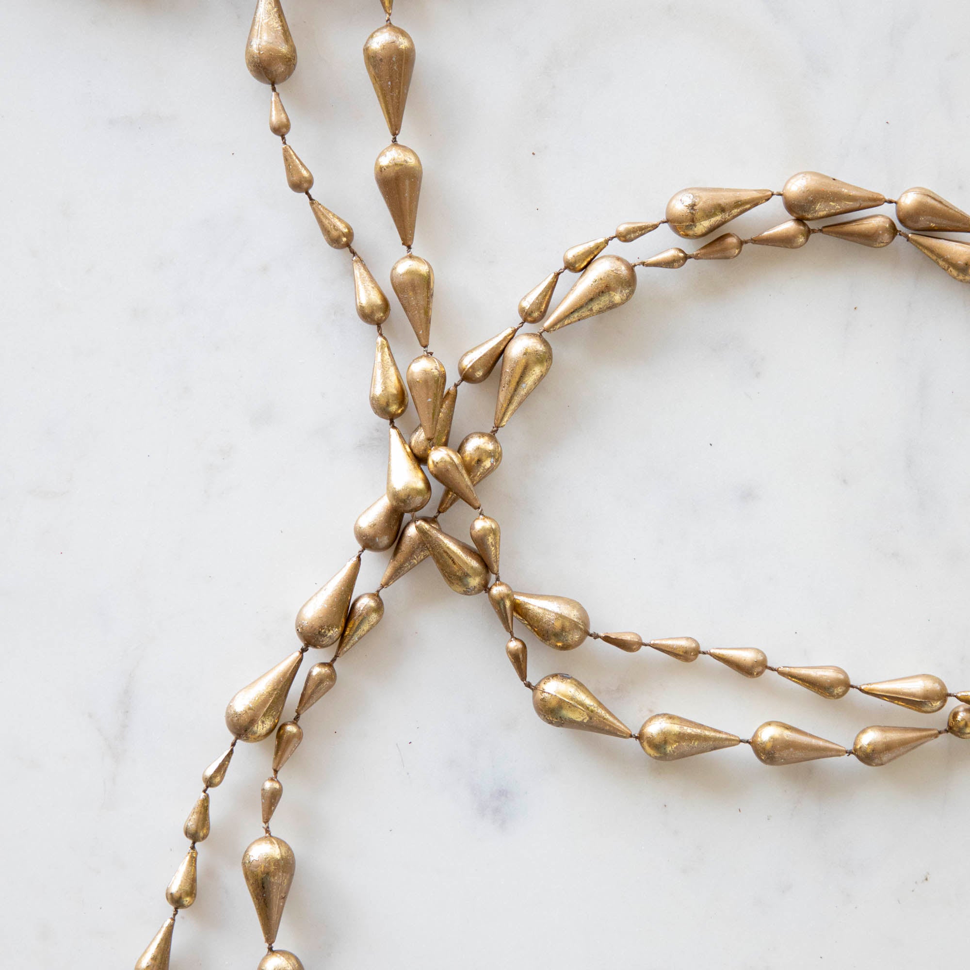 Close up of drop gold garland laying on a table.