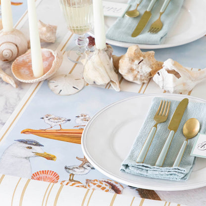 A coastal table setting with the Shorebirds Placemat under a place setting.