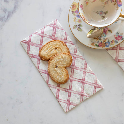 Pink Lattice Guest Napkin next to a tea cup and saucer, under two treats.