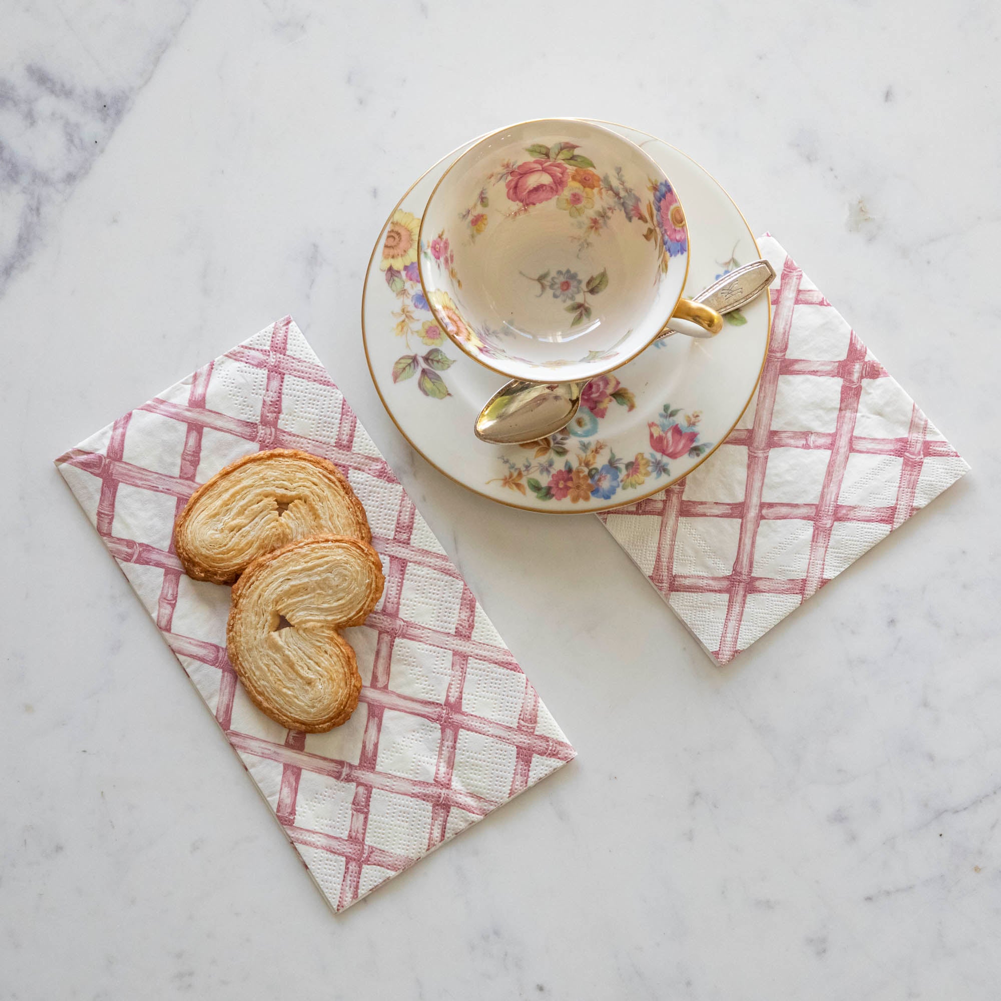 Pink Lattice Cocktail and Guest Napkins next to a tea cup and saucer.