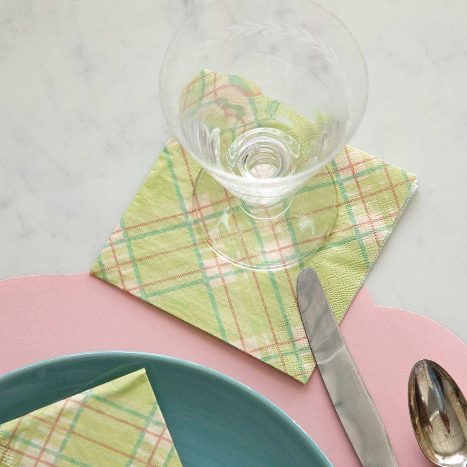 Bright Green Plaid Cocktail Napkin under a glass behind a place setting.