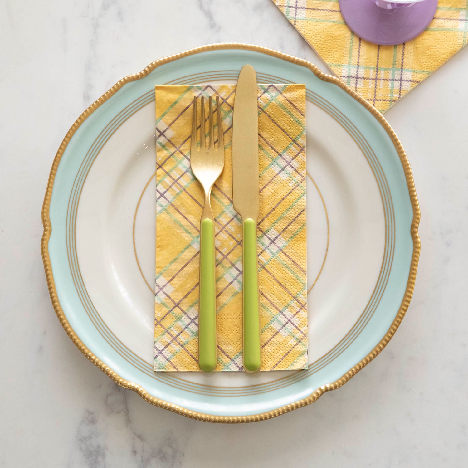 Yellow Plaid Guest Napkin on a plate, underneath flatware.