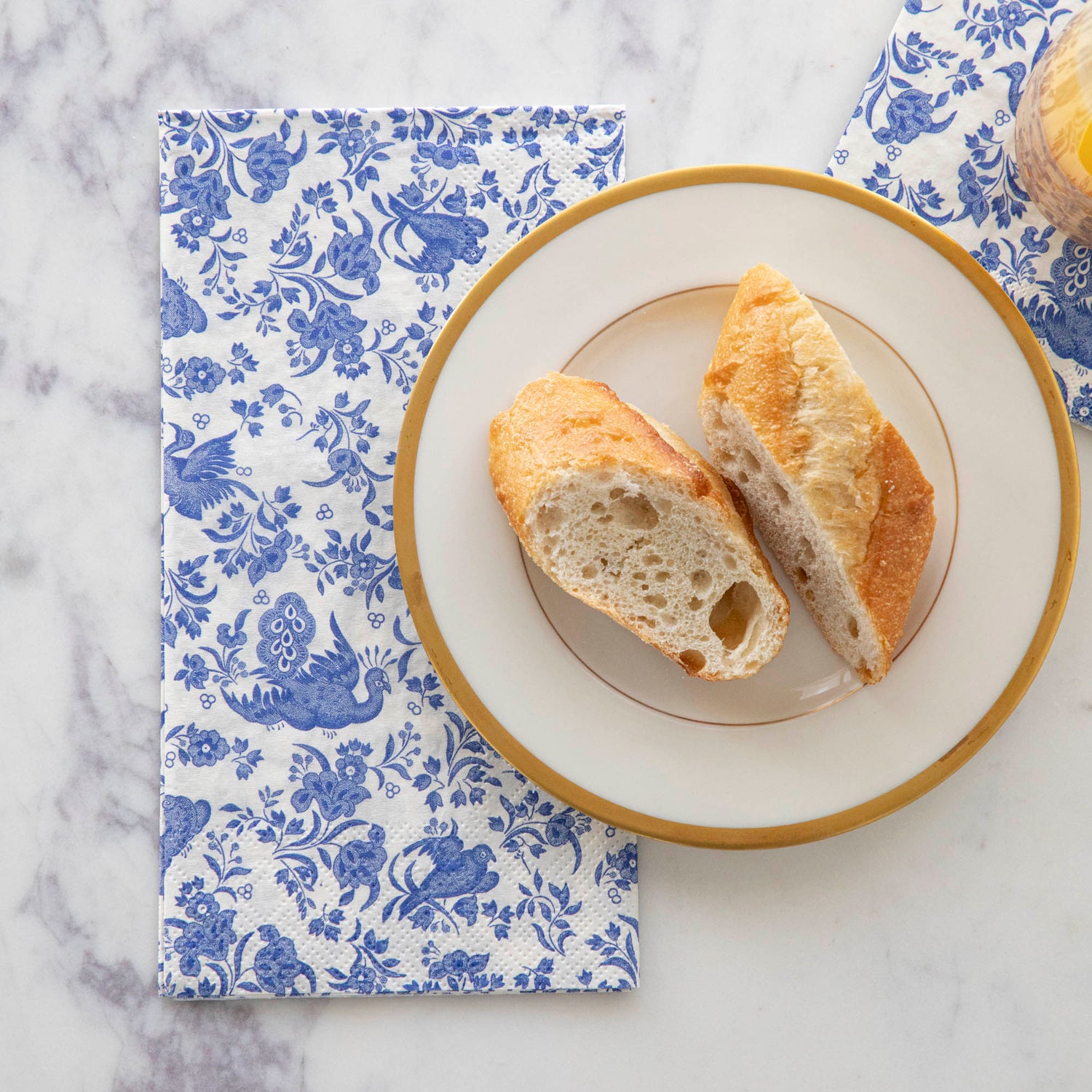 A plate of bread on top of a Blue Regal Peacock Guest Napkin by Hester &amp; Cook.