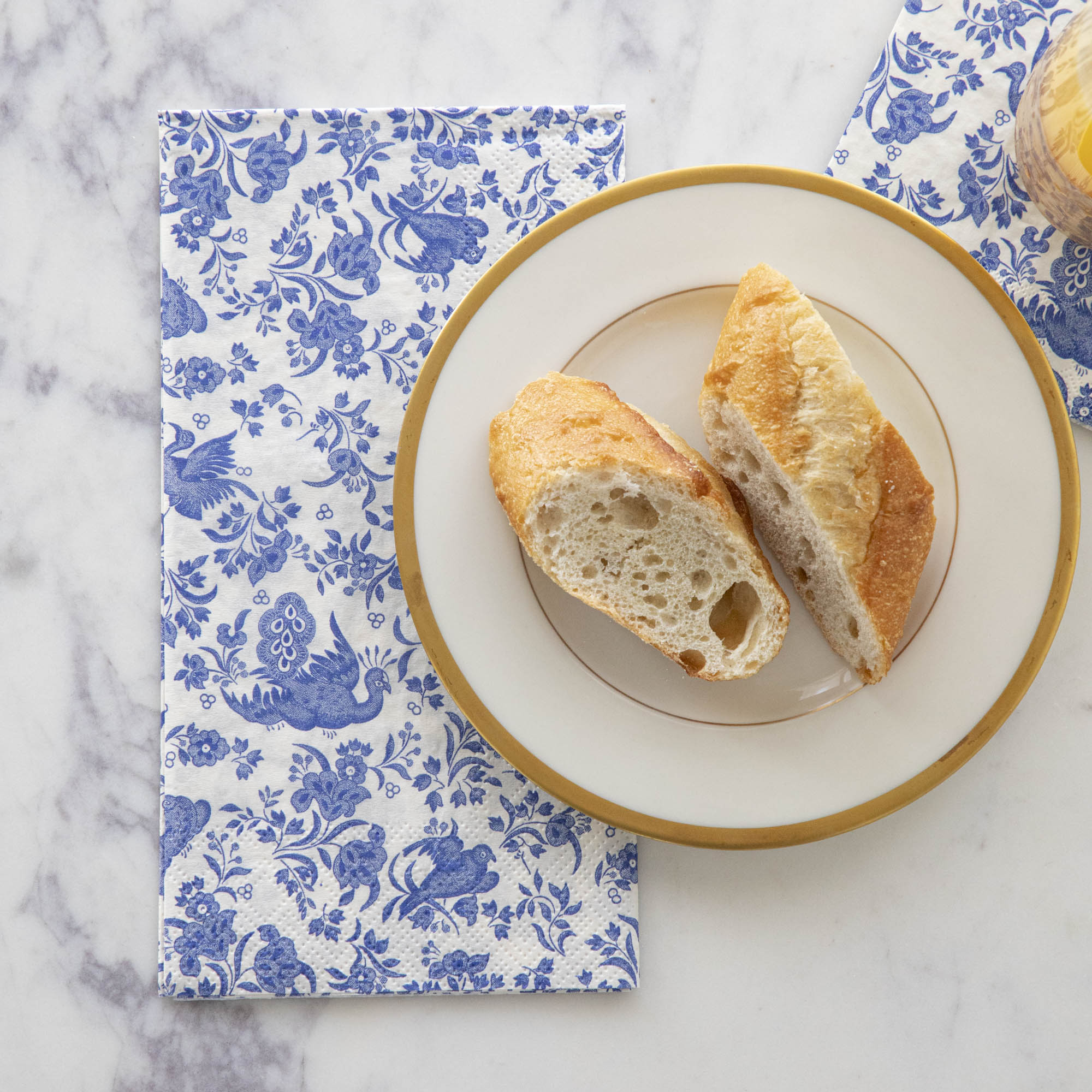 A plate of bread on top of a Blue Regal Peacock Guest Napkin by Hester &amp; Cook.