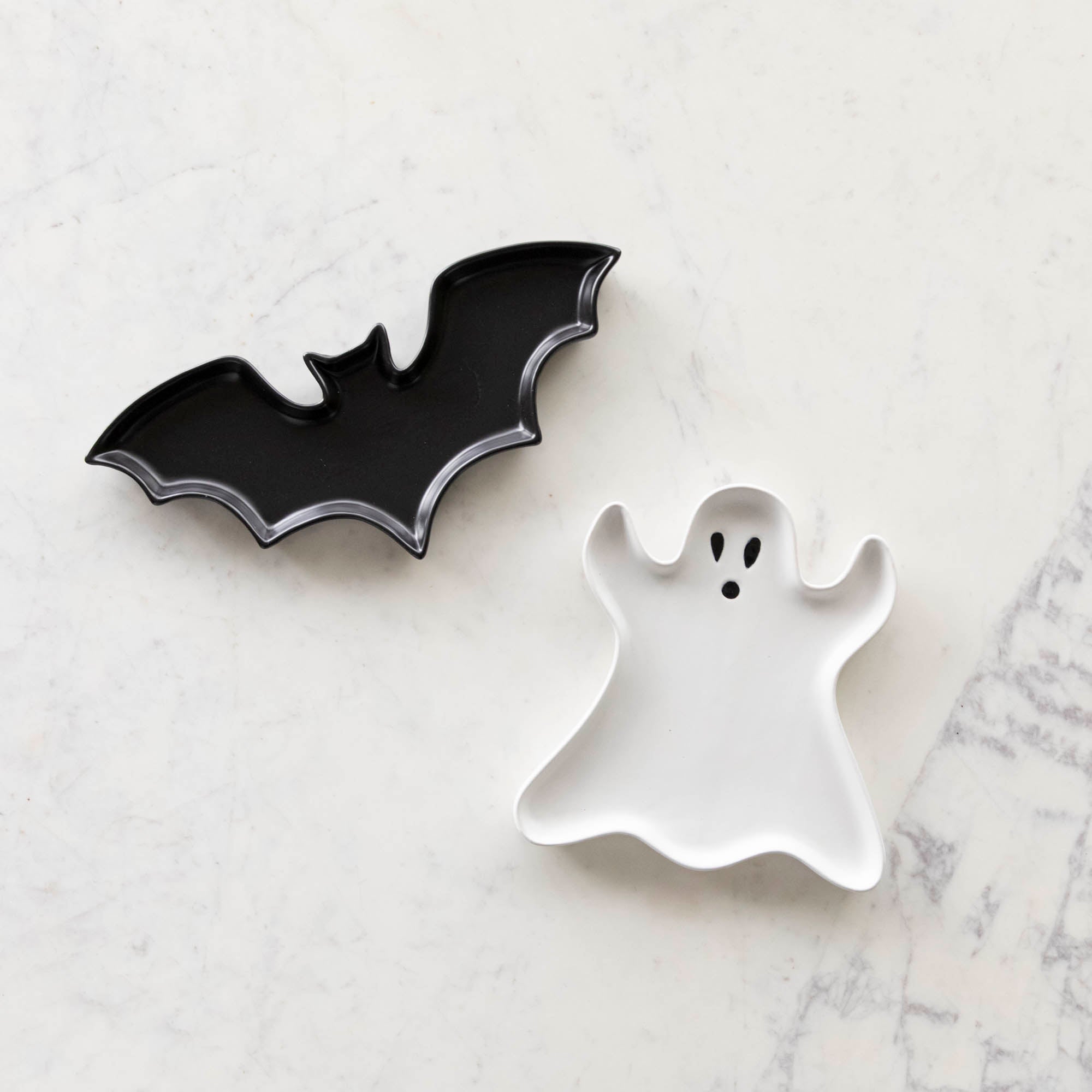 Stoneware Bat Shaped and Ghost Shape Dish on a marble table.