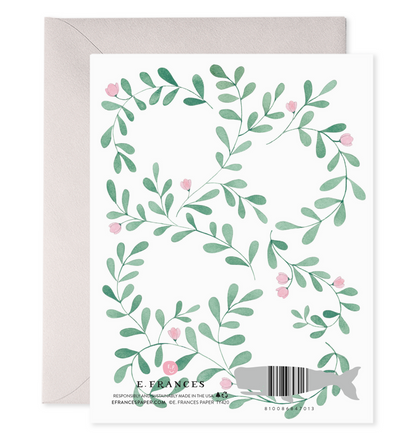 back of card with illustration of greenery with small pink flowers 