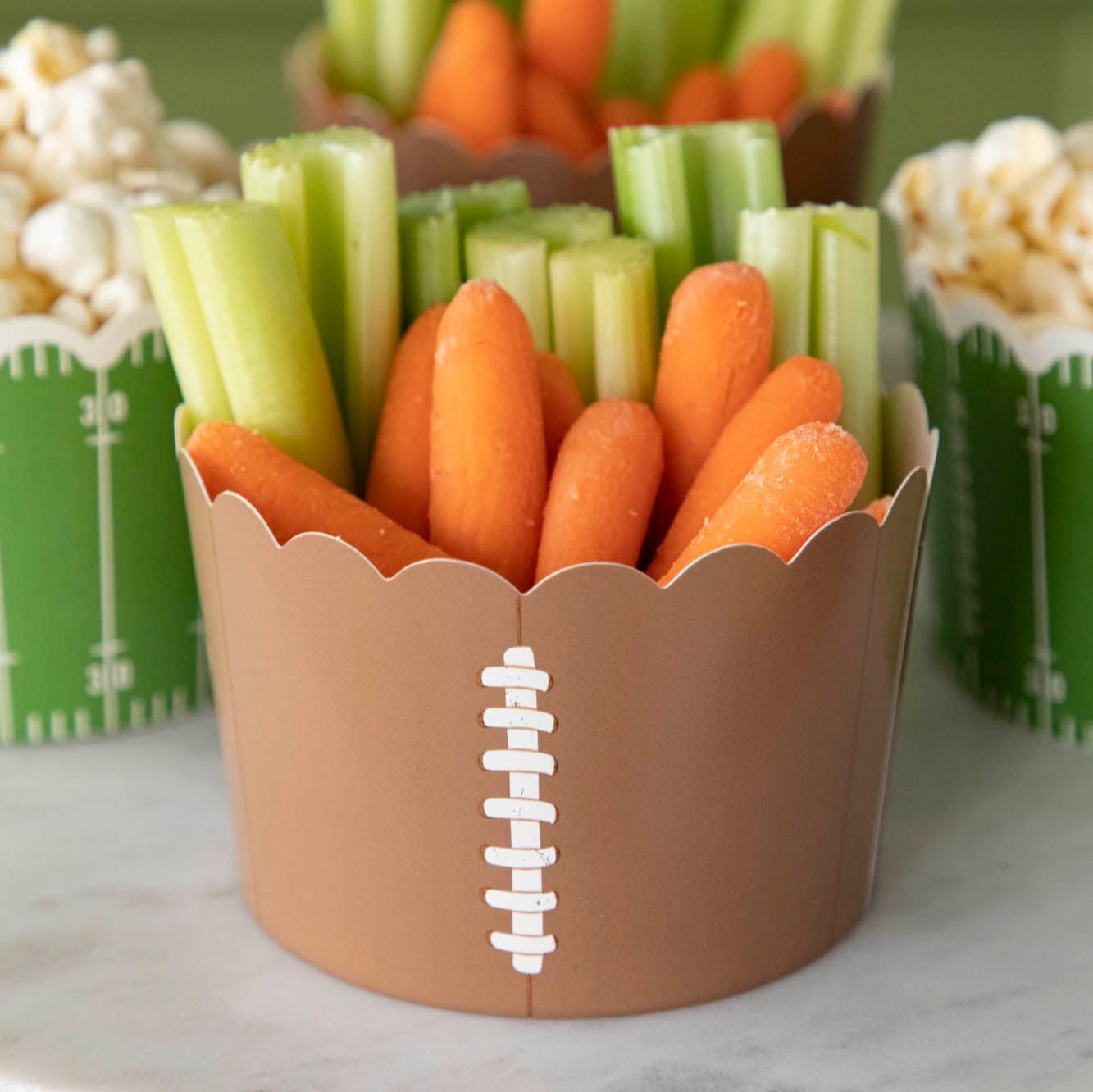 Celery and carrots inside of a football themed paper baking cup.