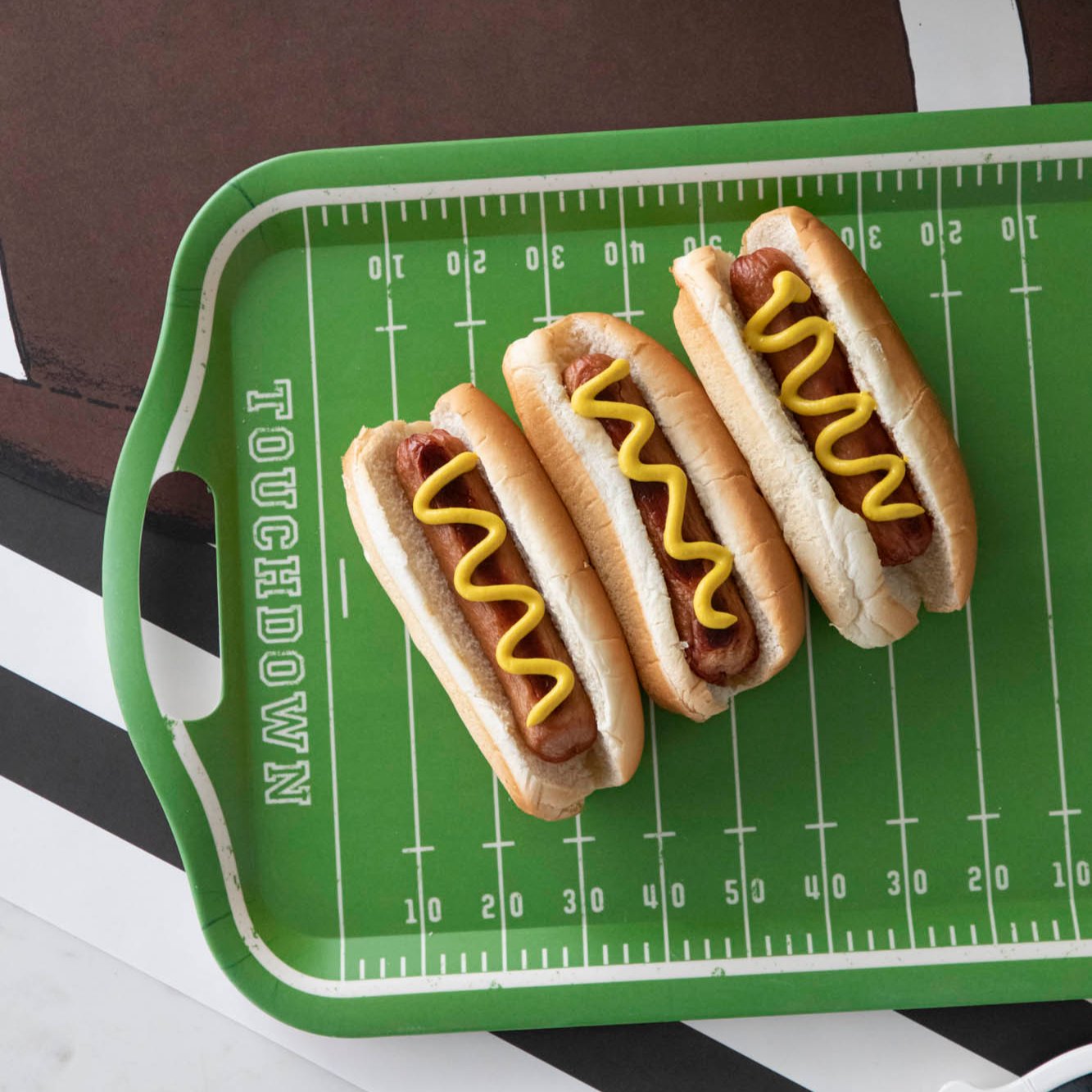 A football field tray with hot dogs on top.