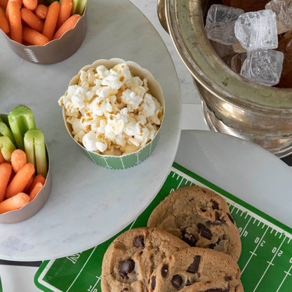 Overhead view of snacks in side of football themed baking cups.