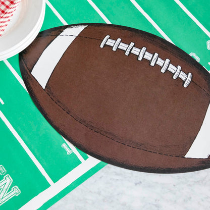 Close up of a die-cut football placemat on a touchdown football field runner.