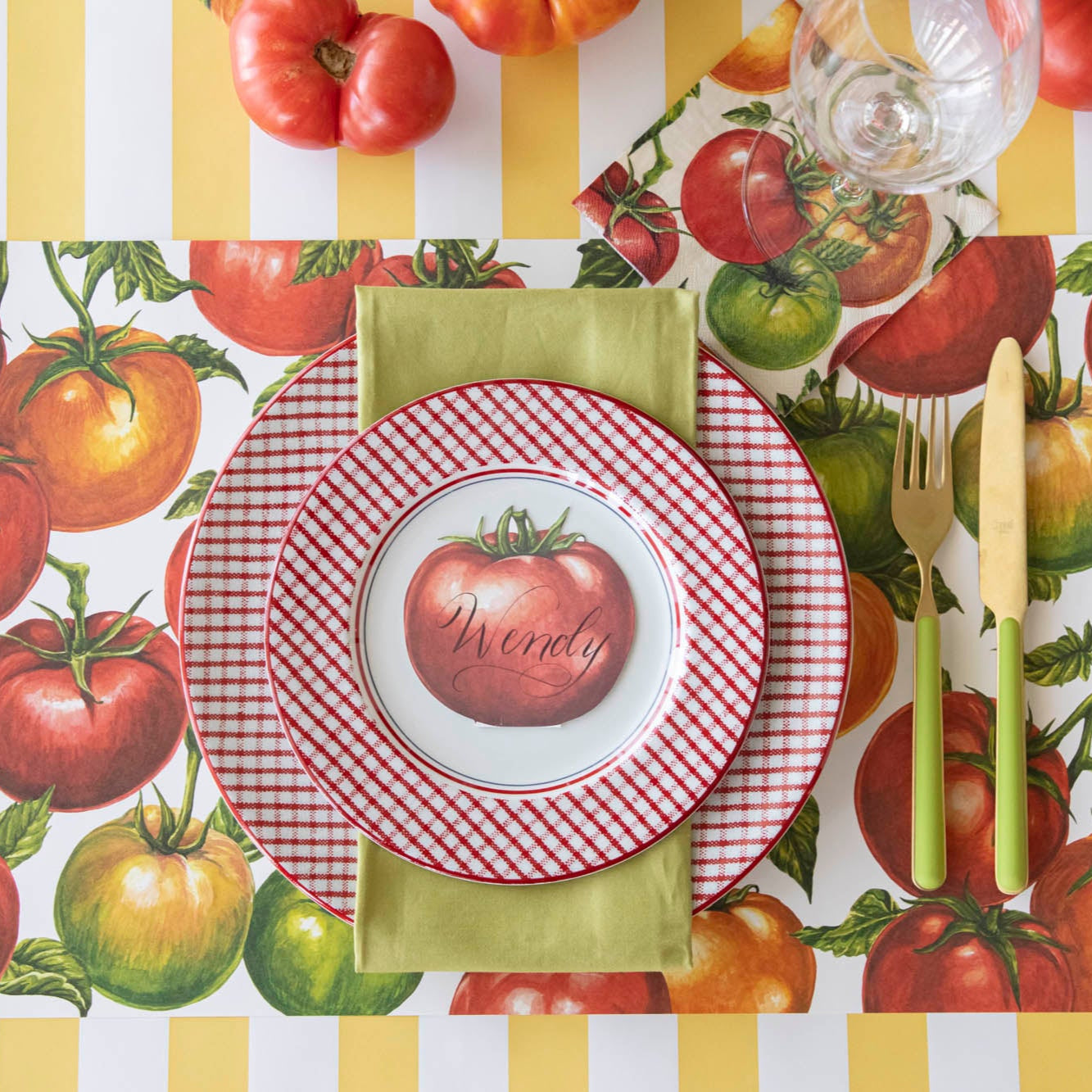 Tomato Cocktail Napkin under a glass behind a place setting.