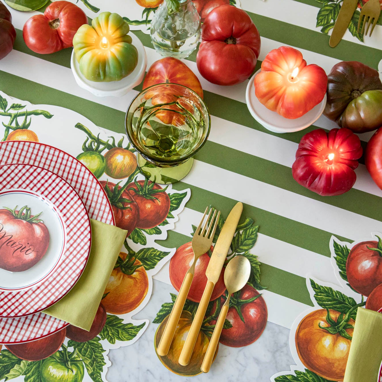 Lit Tomato Candles in the center of a summery, tomato themed table.