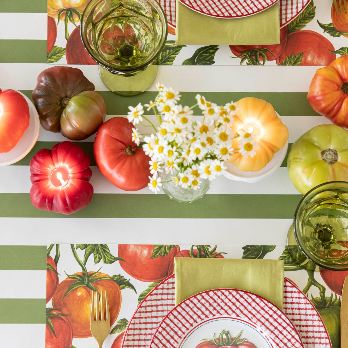 Lit Tomato Candles in the center of a summery, tomato themed table.