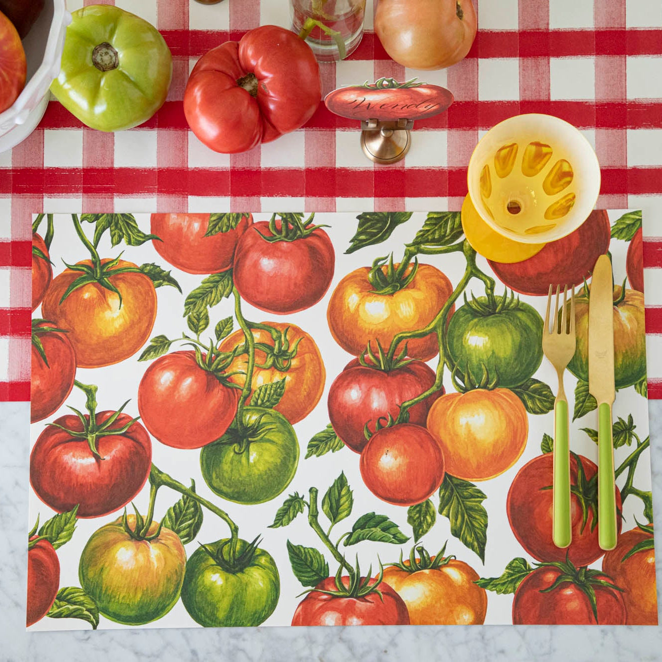 Tomato Vine Placemat on the Red Painted Check Runner with some dinnerware on top.