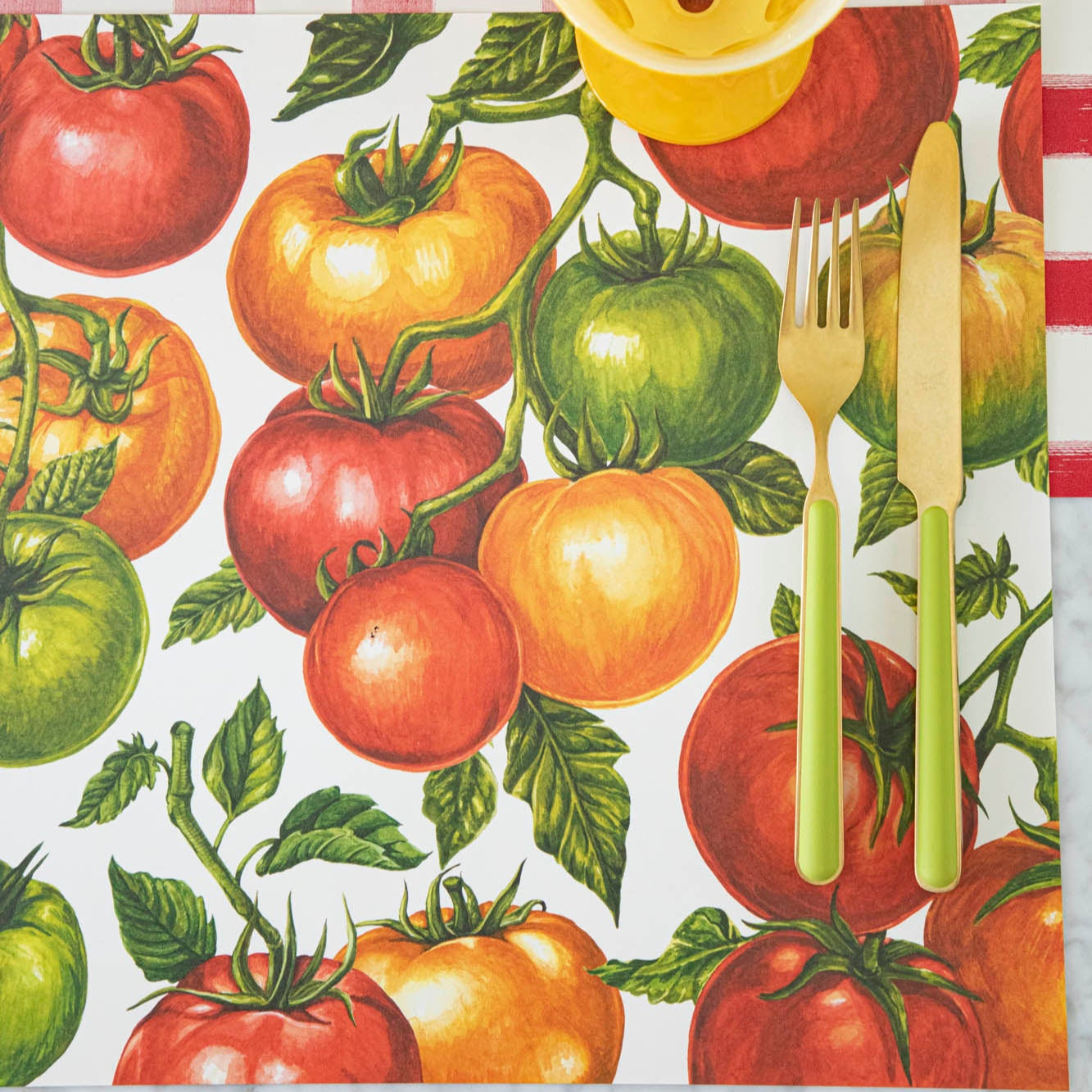 Tomato Vine Placemat with a gold and green fork and knife on top.