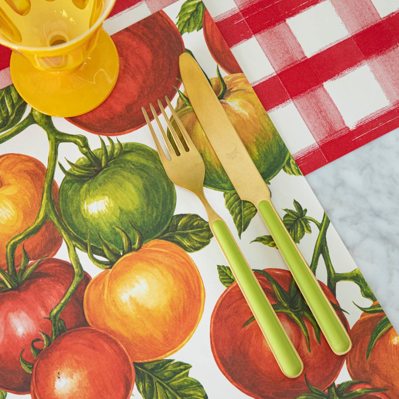 Tomato Vine Placemat on the Red Painted Check Runner with a gold and green silverware on top.