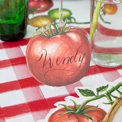 Tomato Place Card with &quot;Wendy&quot; written on it, behind a place setting.