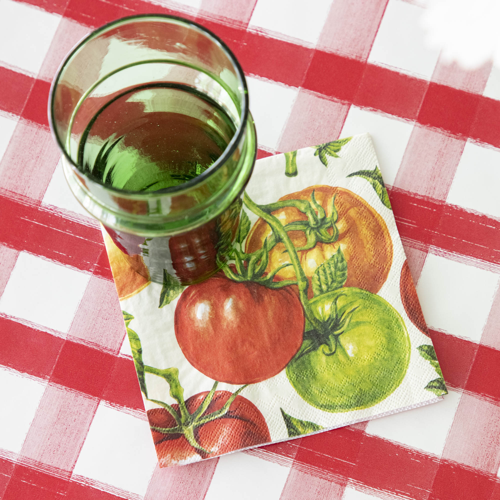 Tomato Cocktail Napkin under a glass and Red Painted Check Runner underneath.