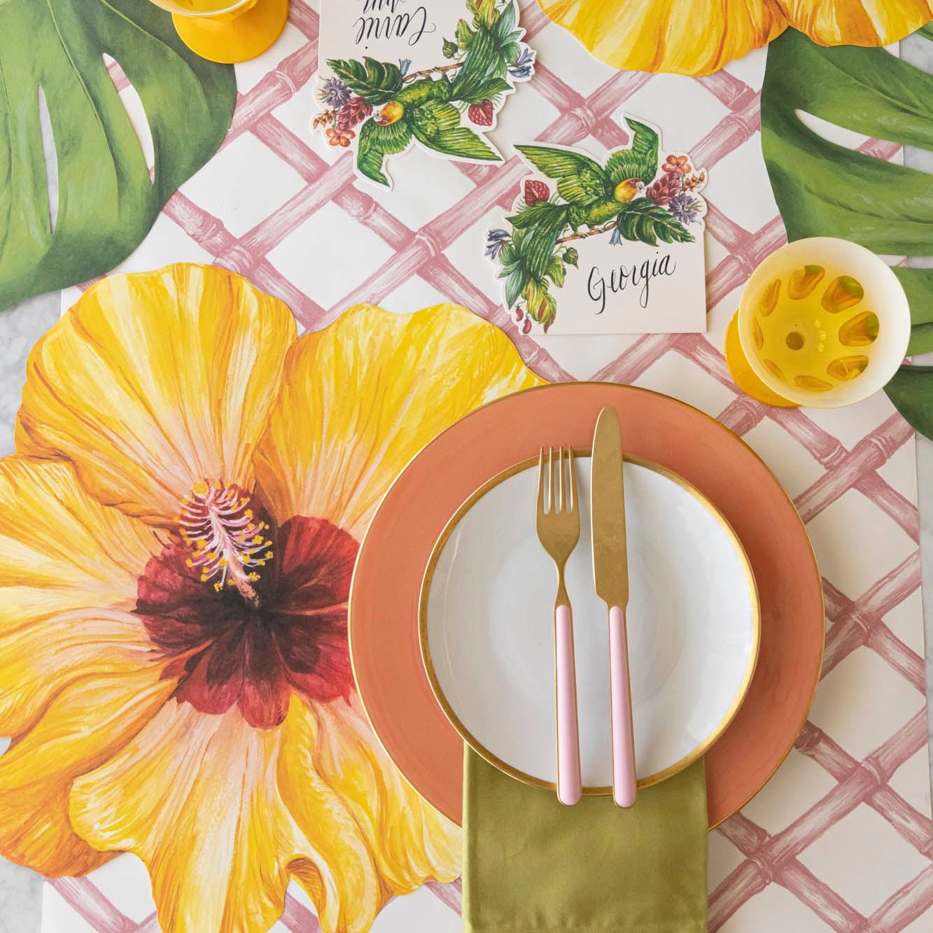 Parrot Place Card with &quot;Georgia&quot; written on it, behind a tropical place setting.