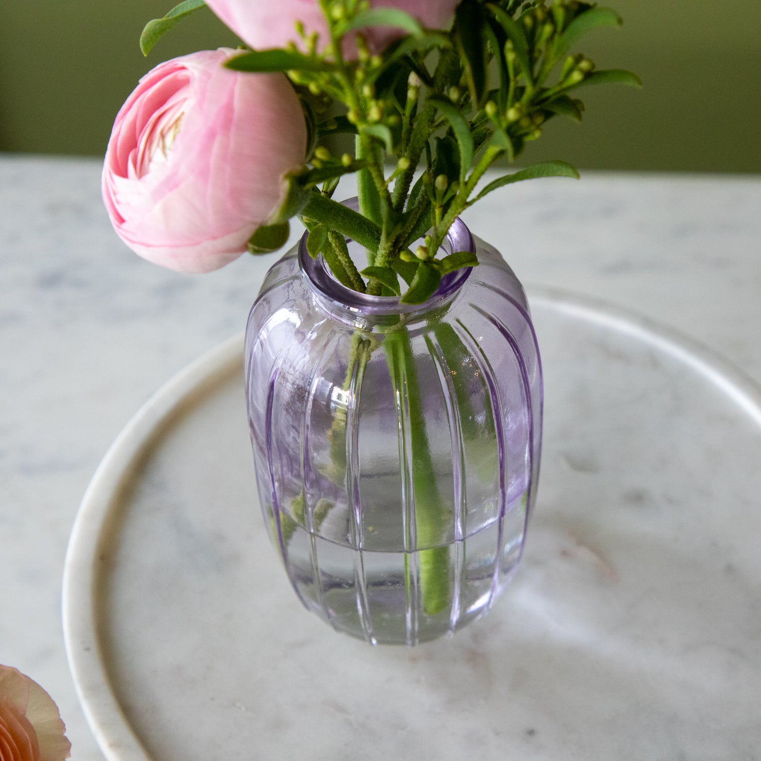 A top down view of the Lilac Glass Bud Vase with flowers in it.