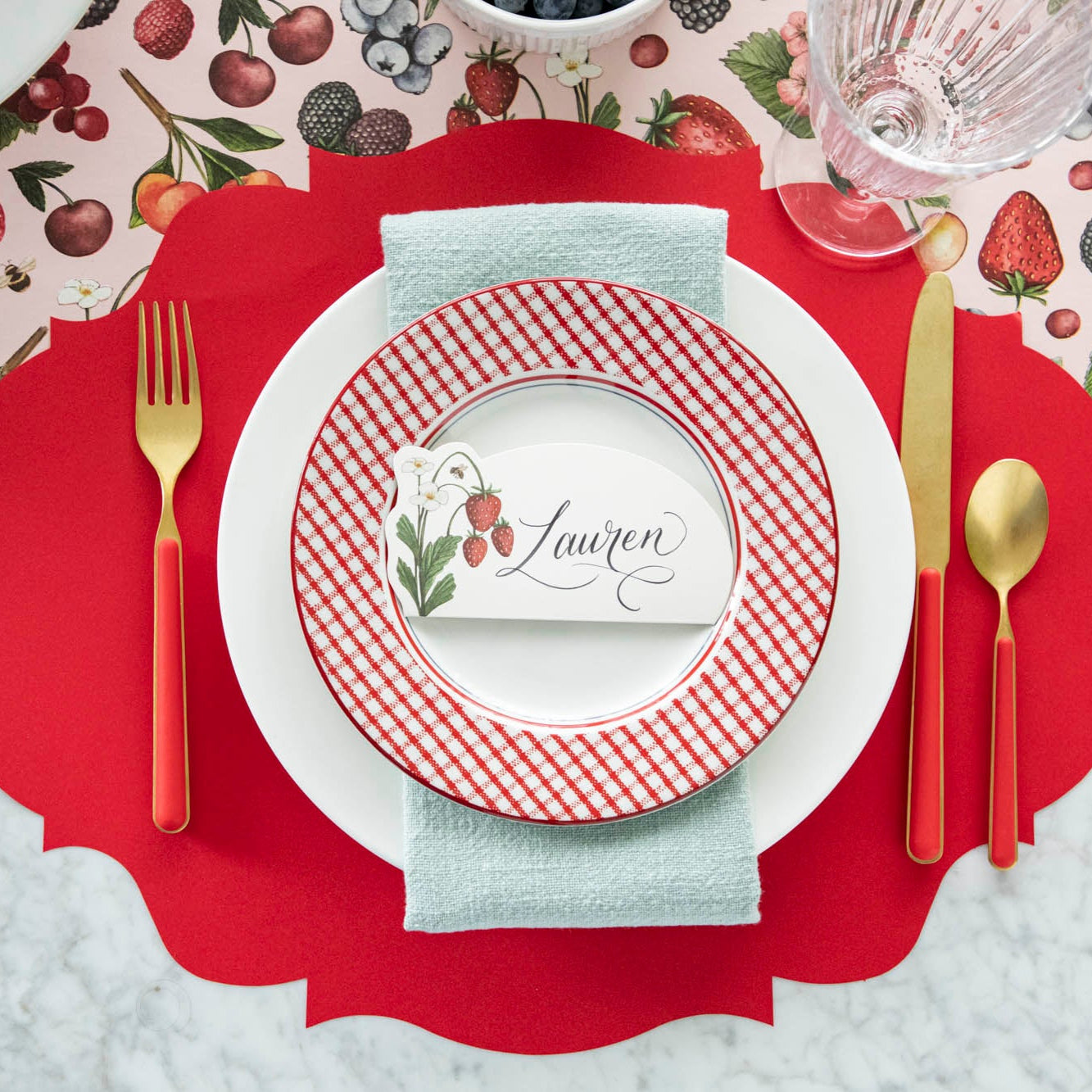 Wild Berry Place Card with &quot;Lauren&quot; written in script, centered on dinner plates on a berry themed place setting.