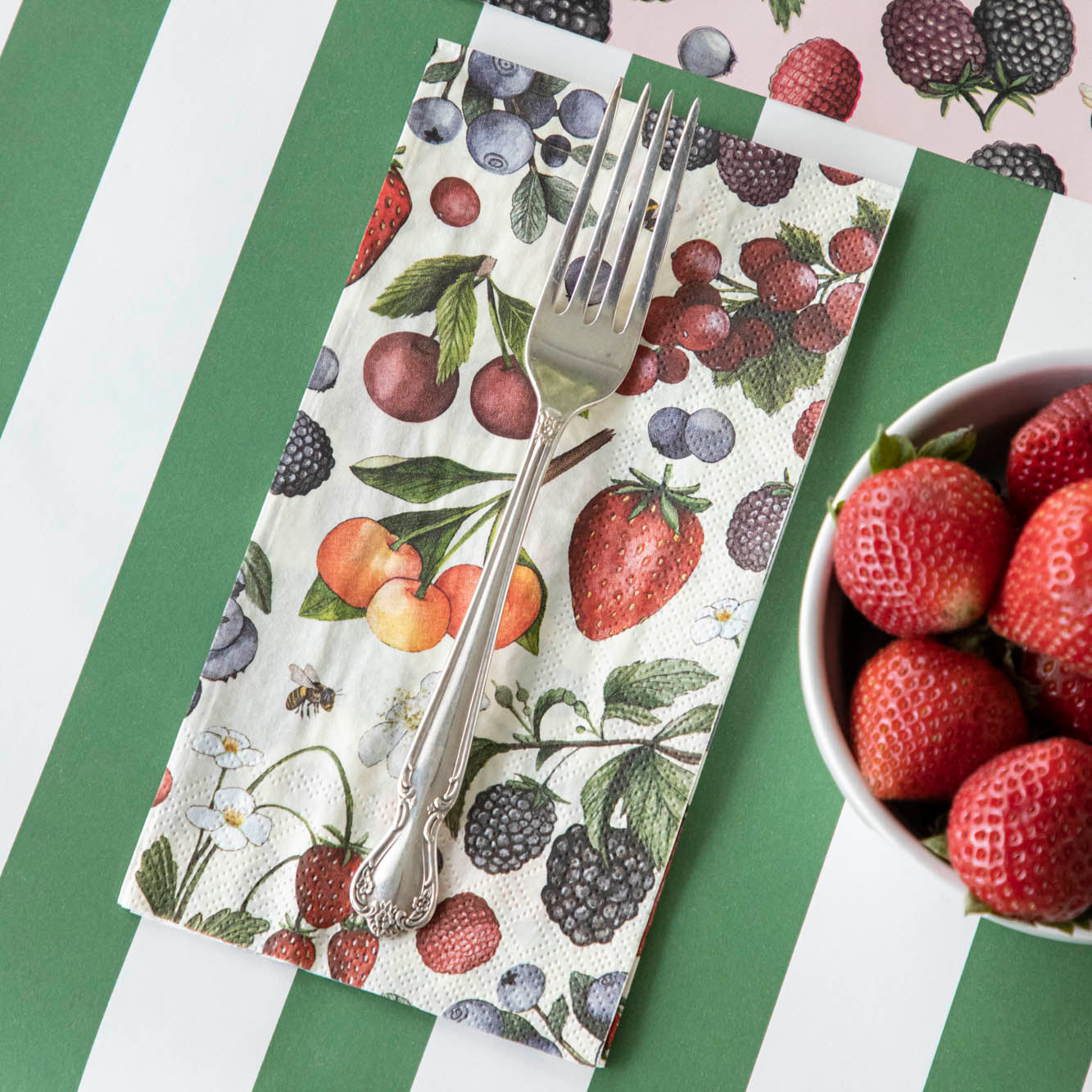 Wild Berry Guest Napkin with a fork on top, on the Dark Green Classic Stripe Runner.