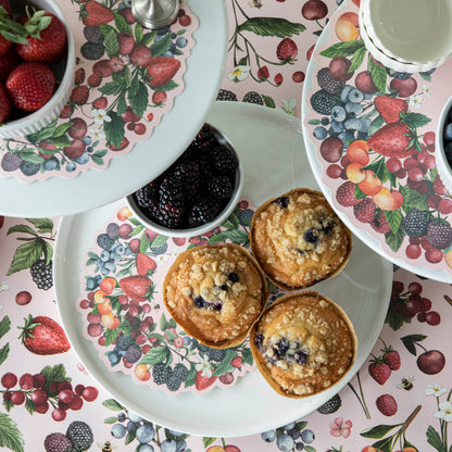 Wild Berry Serving Paper on a cake stand beneath cups of berries and muffins.