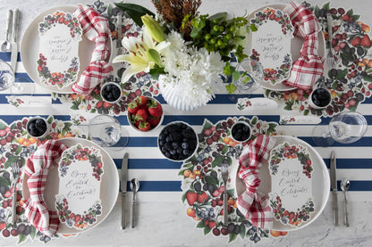 The Die-cut Berry Wreath Placemat under an elegant table setting for four, from above.