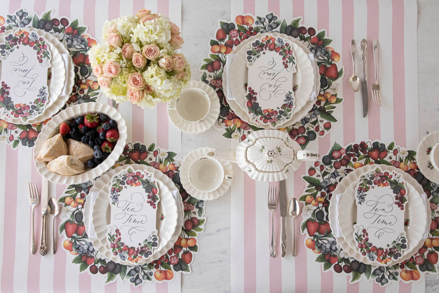 The Die-cut Berry Wreath Placemat under an elegant table setting for four, from above.