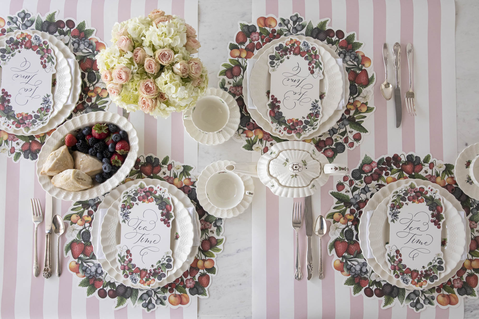 The Die-cut Berry Wreath Placemat under an elegant table setting for four, from above.