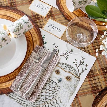 Table setting featuring a Winter Owls Cracker on a white plate, on top of a Die-cut Wood Slice Placemat and Winter Owls Placemat with an Autumn Plaid Runner underneath.