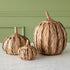 Group of the 3 sizes of woven pumpkins on a marble table with a green backdrop.