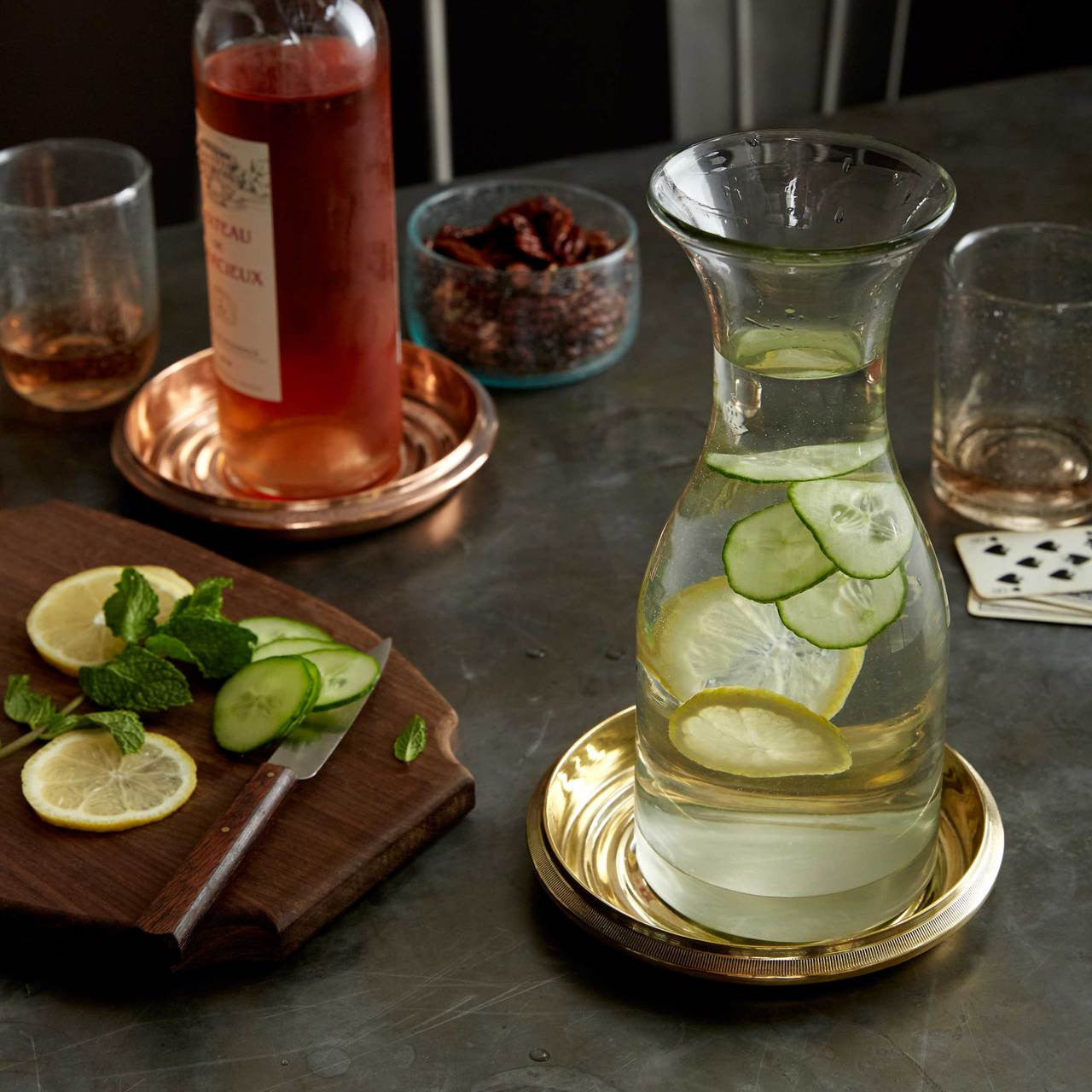 Brass Bottle Coaster on a table with assorted glasses and carafes.  