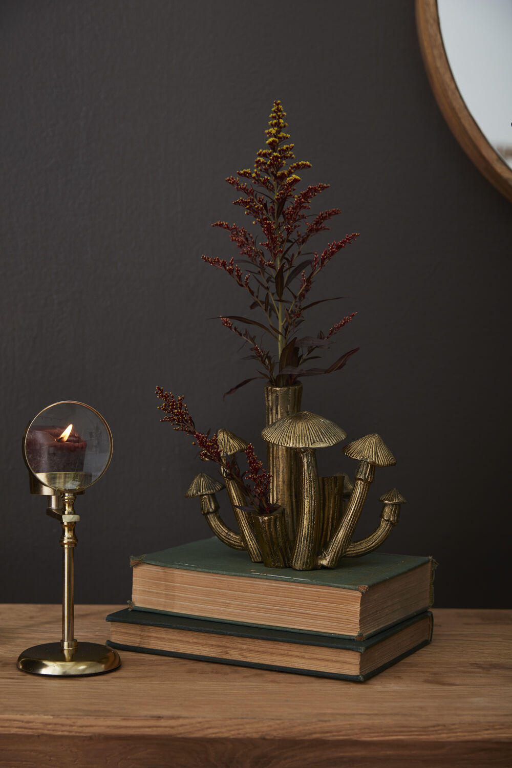 Brass Mushroom Cluster Budvase on a book with a plant in it.