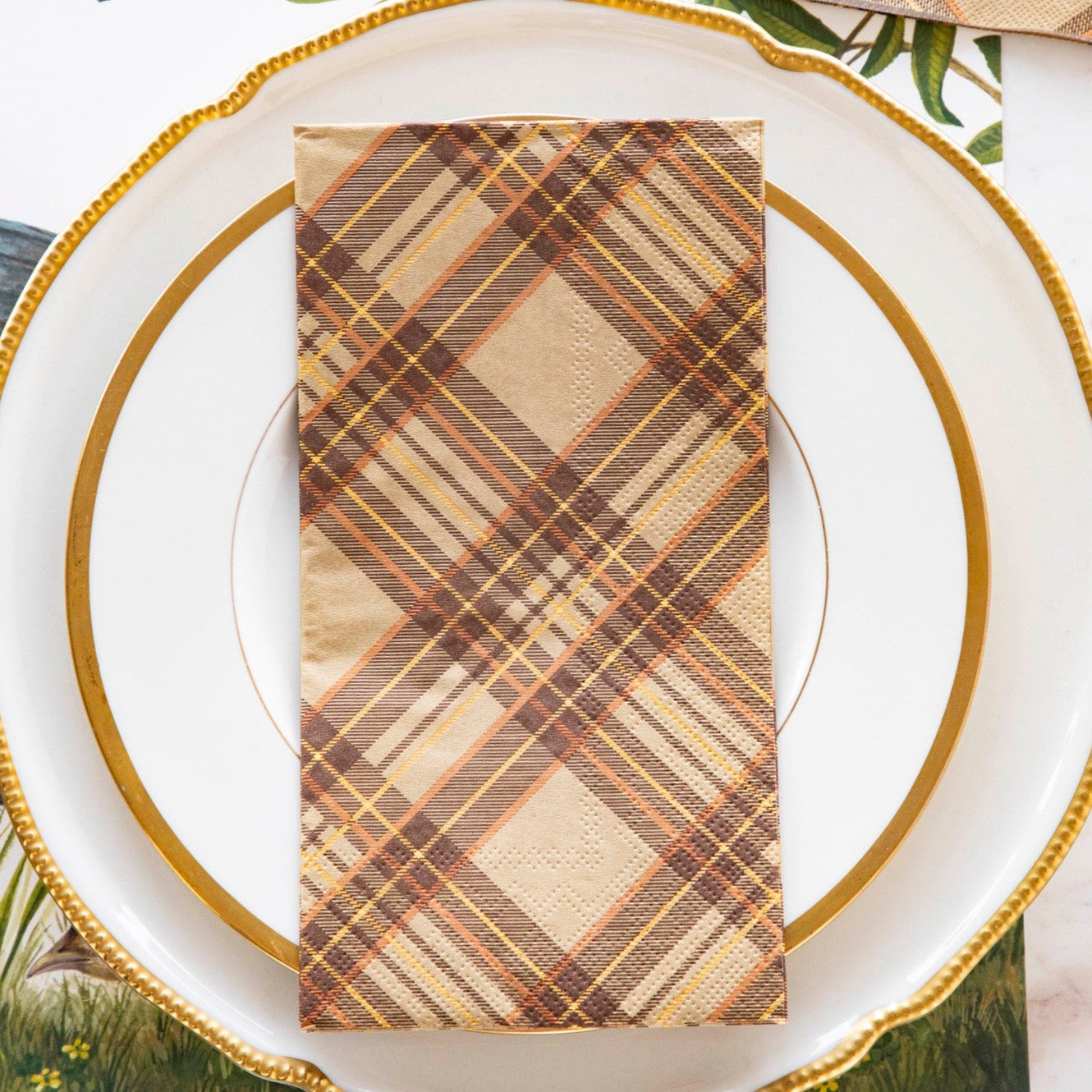 An Autumn Plaid Guest Napkin on a dinner plate in an elegant Thanksgiving place setting.