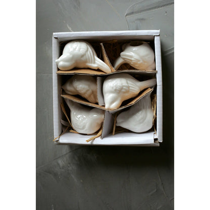 Ceramic white birds in their box.