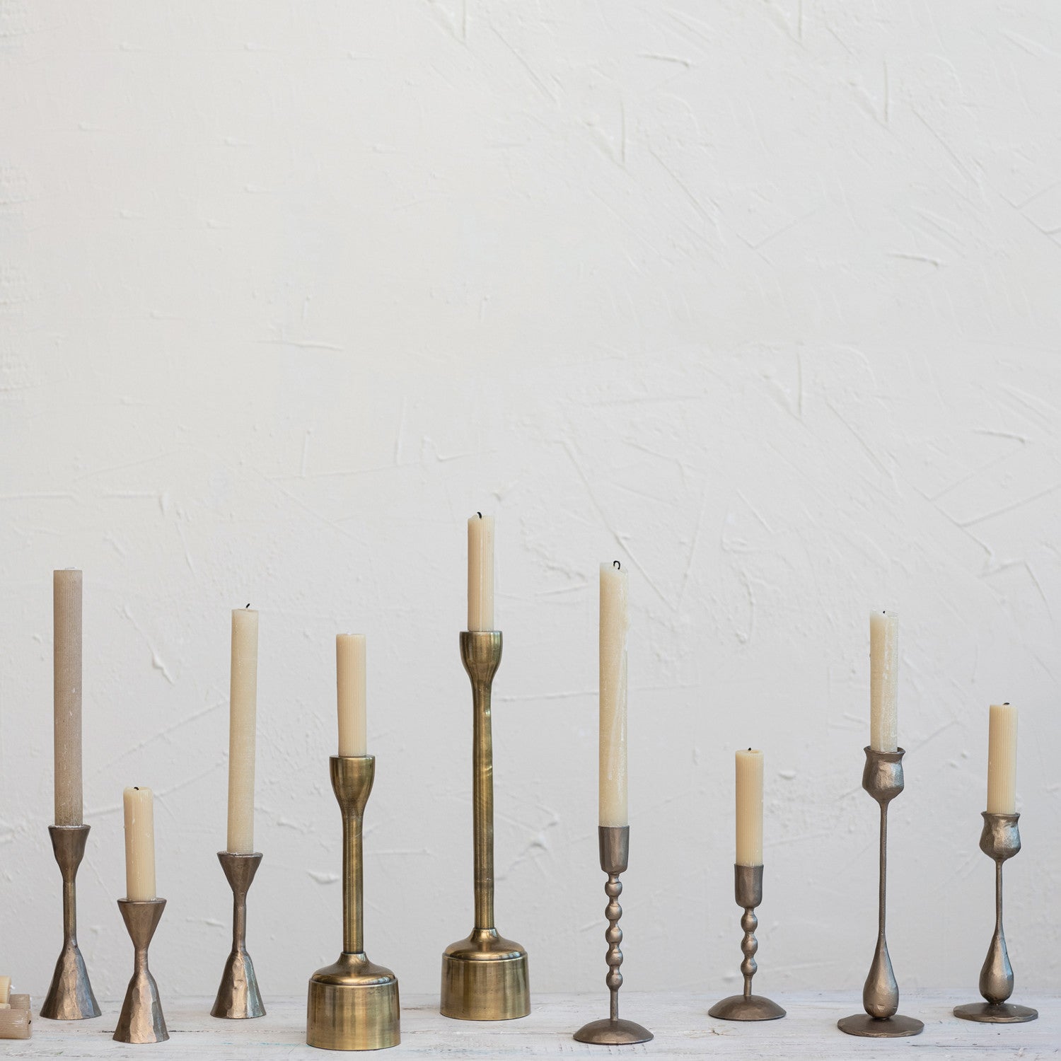 Collection of brass colored candle holders by Creative Co-op.