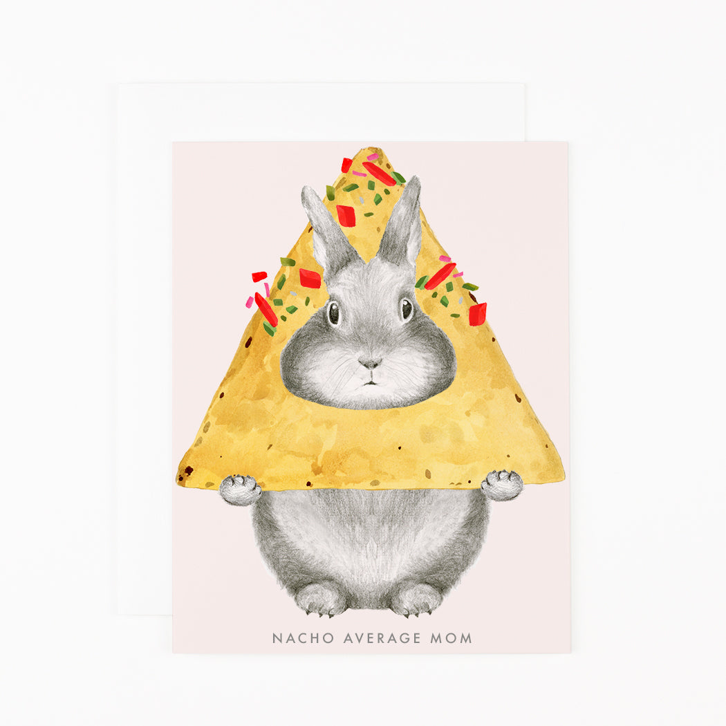 A Dear Hancock greetings card of a hand-drawn, graphite bunny peeking through a nacho with text that reads &quot;NACHO AVERAGE MOM&quot;.