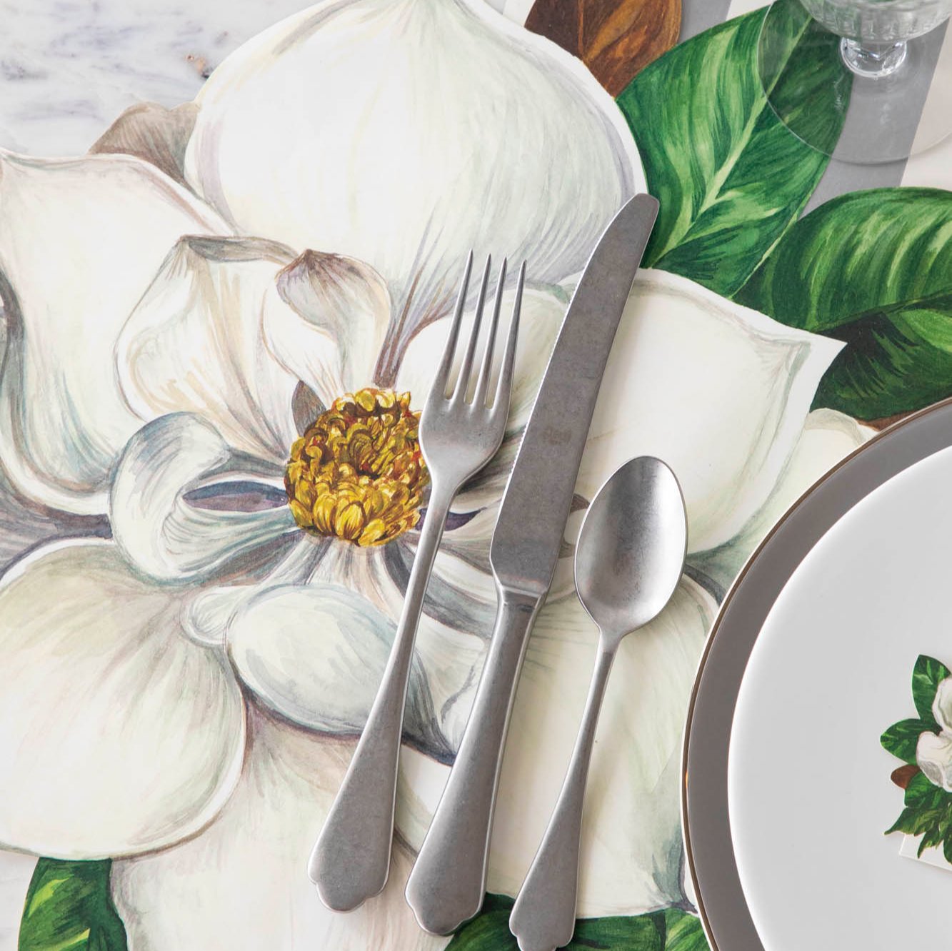 Die-cut Magnolia Placemat with silverware on top.